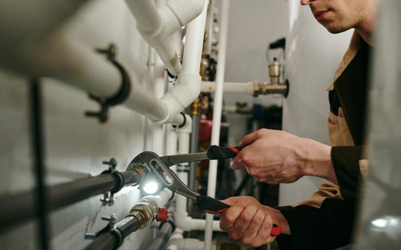 A man using a tool to fix parts of pipes during work